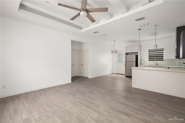 907 W Carmel Ave, Pharr, TX 78577 - unfurnished living room with a sink, a ceiling fan, wood finished floors, beam ceiling, and baseboards