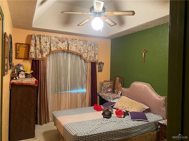 carpeted bedroom with ceiling fan and a textured ceiling