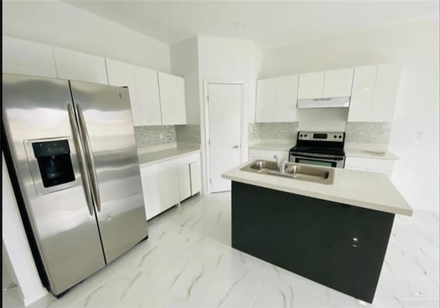 kitchen with backsplash, a kitchen island with sink, sink, appliances with stainless steel finishes, and white cabinetry