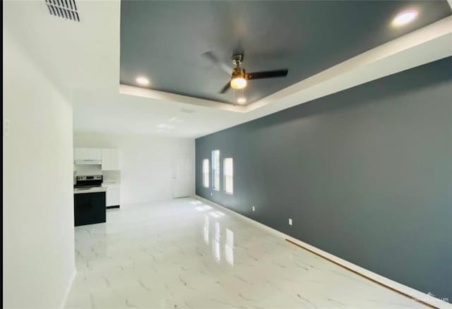 spare room featuring a tray ceiling and ceiling fan