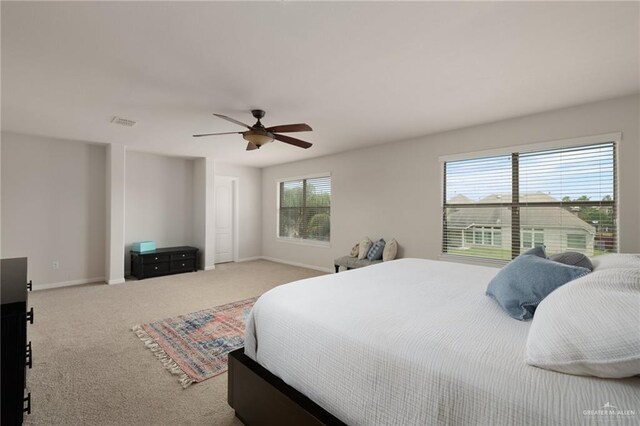 carpeted bedroom with baseboards, visible vents, and a ceiling fan