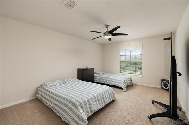 carpeted bedroom featuring baseboards, visible vents, and a ceiling fan
