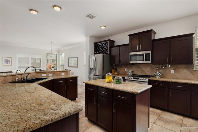 kitchen featuring light tile patterned floors, a sink, visible vents, stainless steel appliances, and a center island