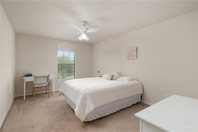 bedroom with baseboards, a ceiling fan, and light colored carpet
