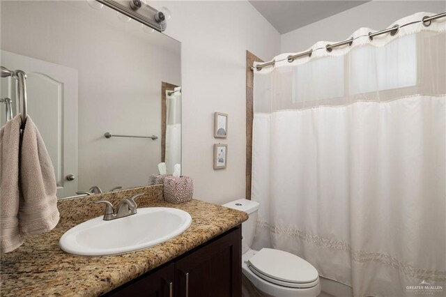bathroom featuring toilet, a shower with curtain, and vanity