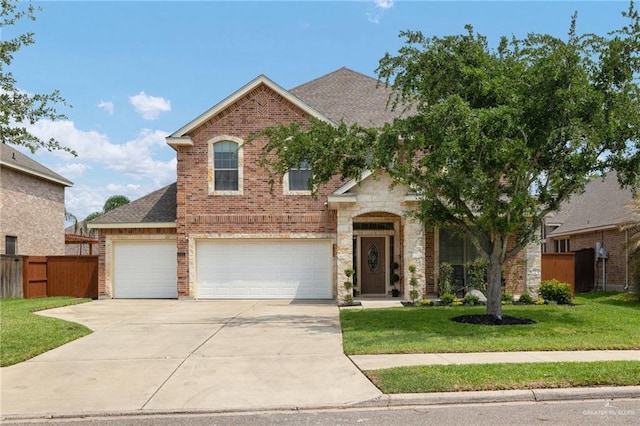 traditional-style house featuring a front yard, driveway, brick siding, an attached garage, and fence