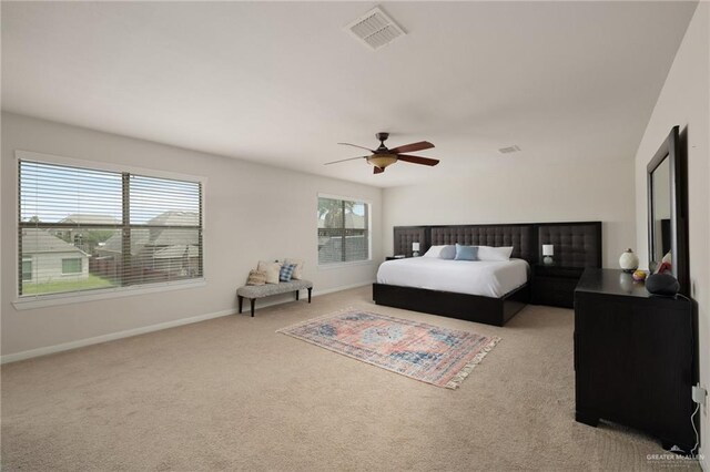 bedroom featuring visible vents, baseboards, a ceiling fan, and light carpet