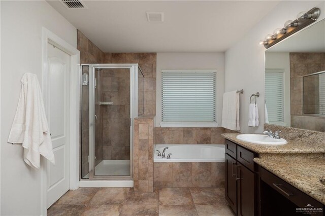 bathroom with visible vents, a shower stall, a bath, and vanity