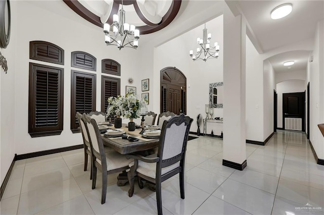 dining room featuring arched walkways, light tile patterned floors, baseboards, and an inviting chandelier