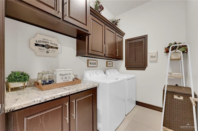 clothes washing area featuring washing machine and dryer, cabinet space, baseboards, and light tile patterned flooring