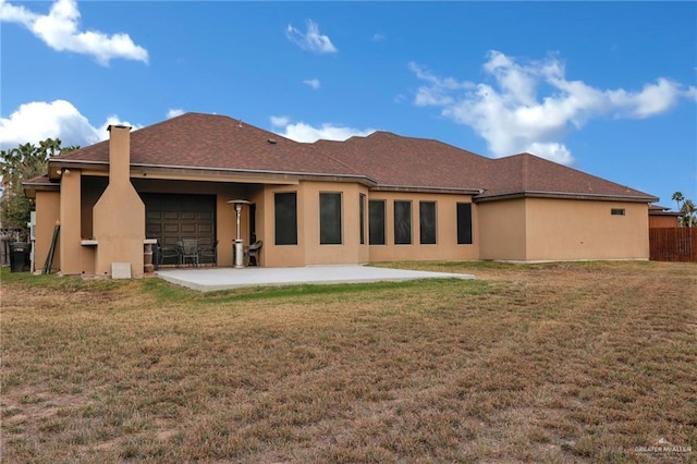 rear view of property with stucco siding, a patio, fence, and a lawn