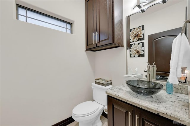 bathroom featuring vanity, toilet, and baseboards