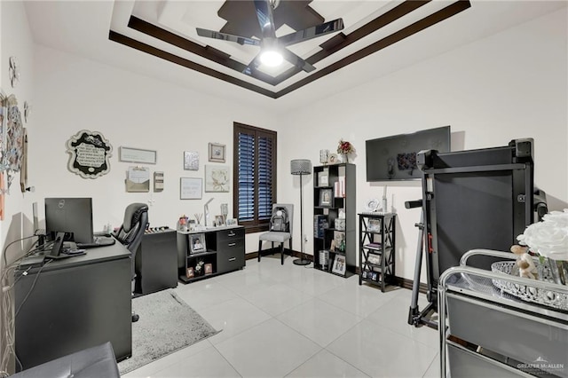 office area with ceiling fan, light tile patterned floors, a raised ceiling, and baseboards