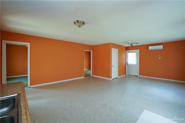 24834 Birch St, San Benito, TX 78586 - unfurnished living room with baseboards, a sink, a ceiling fan, and an AC wall unit