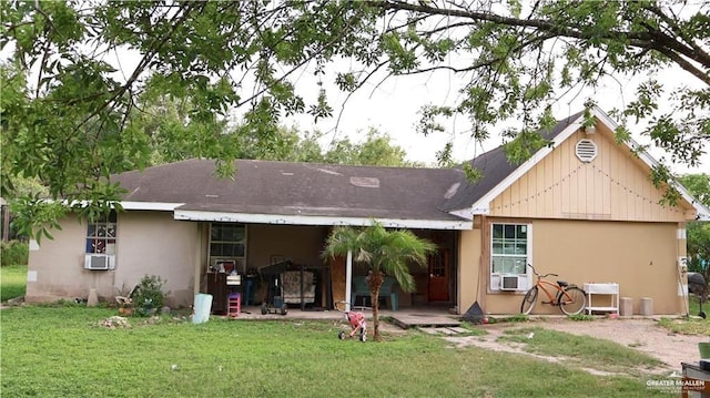 rear view of property featuring cooling unit, a patio area, and a lawn