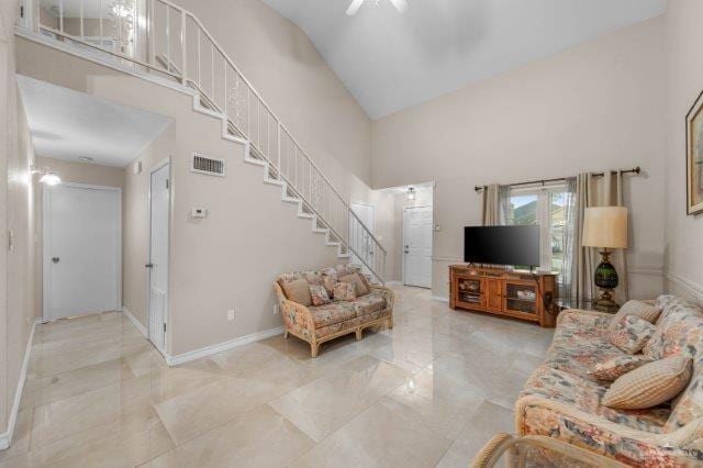 living room with ceiling fan and high vaulted ceiling