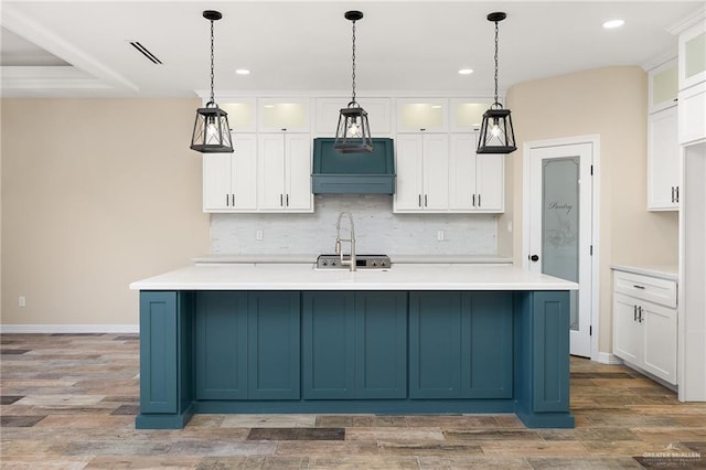 1008 Magnolia St, Mission, TX 78573 - kitchen with recessed lighting, backsplash, white cabinetry, light countertops, and light wood-type flooring