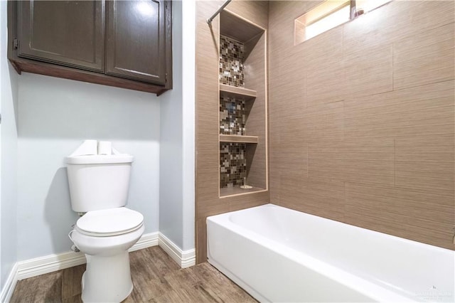 full bath featuring  shower combination, baseboards, toilet, and wood finished floors