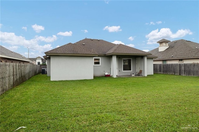 back of property featuring a lawn and central air condition unit