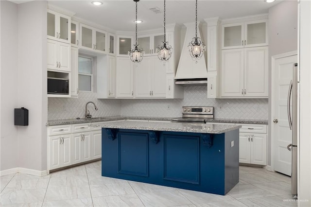 kitchen featuring a center island, white cabinets, custom exhaust hood, and appliances with stainless steel finishes