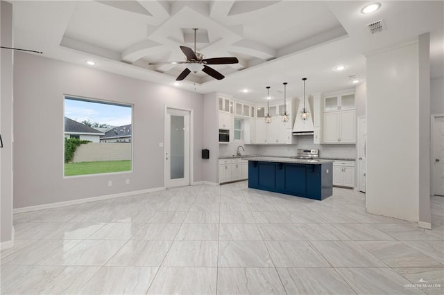 kitchen featuring white cabinets, sink, hanging light fixtures, decorative backsplash, and a kitchen island