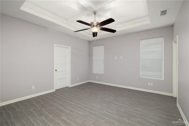 empty room featuring a raised ceiling, ceiling fan, and hardwood / wood-style flooring