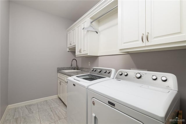 washroom featuring cabinets, sink, and washing machine and clothes dryer