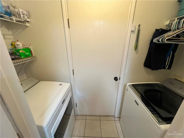 laundry room featuring light tile patterned floors and washing machine and clothes dryer