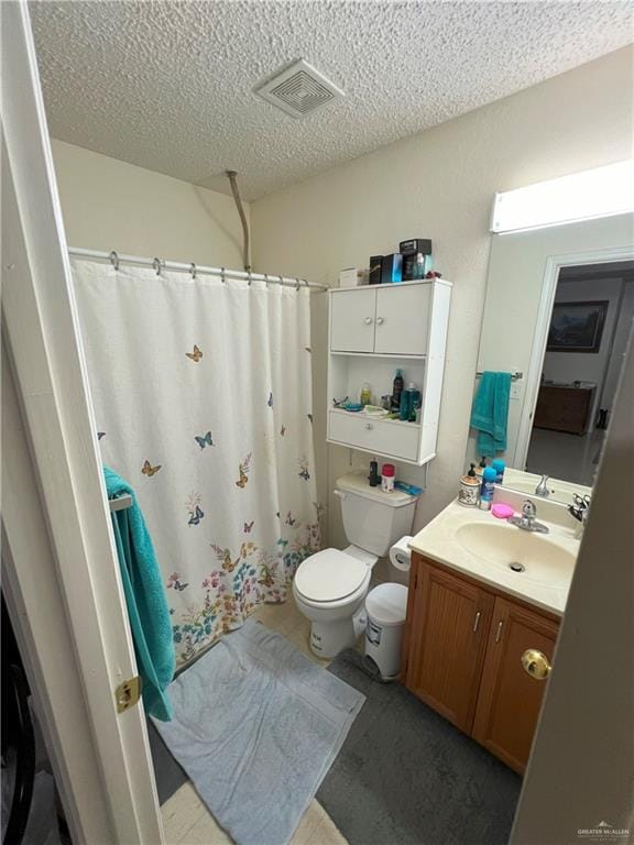 bathroom featuring a textured ceiling, vanity, toilet, and a shower with curtain