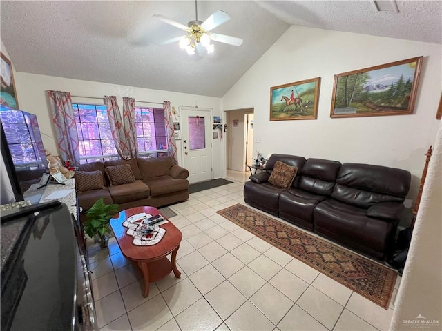 living room featuring ceiling fan, light tile patterned flooring, lofted ceiling, and a textured ceiling