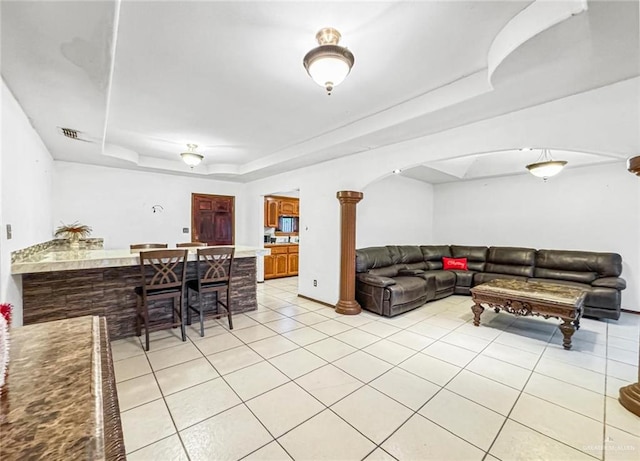 living room featuring light tile patterned floors and a tray ceiling