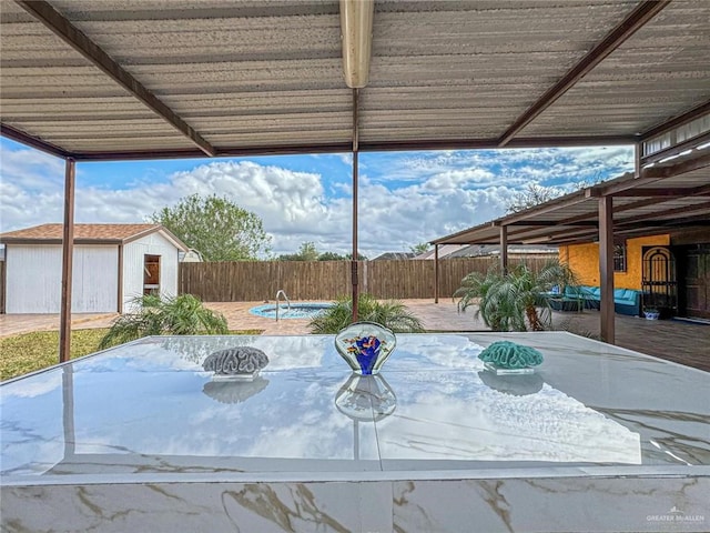 view of patio / terrace featuring a swimming pool and a storage shed