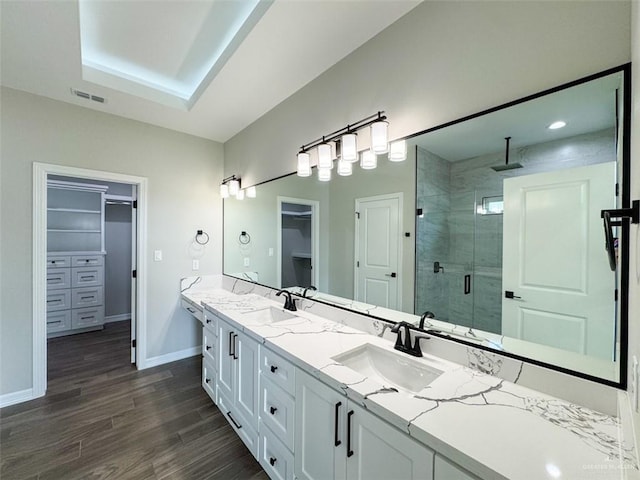 3807 Crimson St, Mission, TX 78574 - full bathroom with a shower stall, double vanity, a spacious closet, baseboards, and wood finished floors
