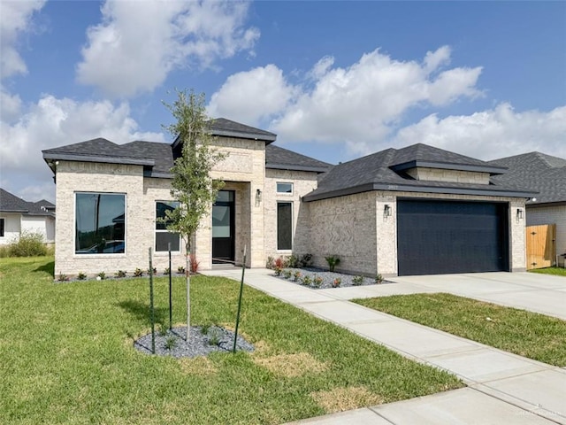 3807 Crimson St, Mission, TX 78574 - view of front facade with a front lawn, an attached garage, concrete driveway, brick siding, and a shingled roof