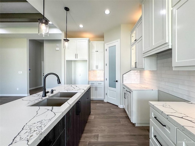 3807 Crimson St, Mission, TX 78574 - kitchen with a sink, light stone countertops, dark wood-style floors, recessed lighting, and white cabinets