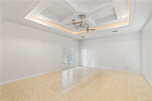 tiled empty room with ceiling fan, a towering ceiling, french doors, and coffered ceiling