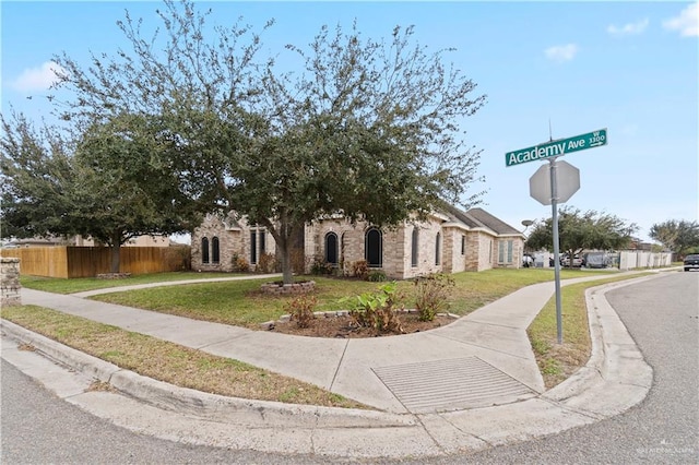 view of property hidden behind natural elements featuring a front lawn