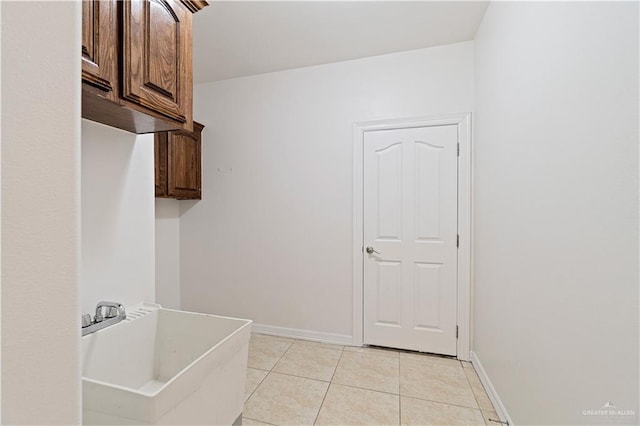 laundry room with light tile patterned flooring and sink