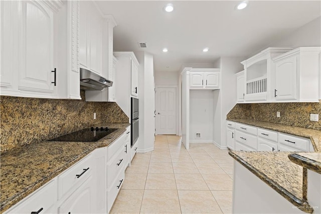 kitchen featuring black electric cooktop, light tile patterned floors, white cabinetry, and dark stone counters