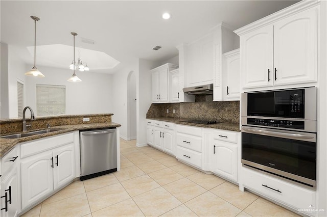 kitchen featuring dark stone countertops, sink, stainless steel appliances, white cabinets, and hanging light fixtures