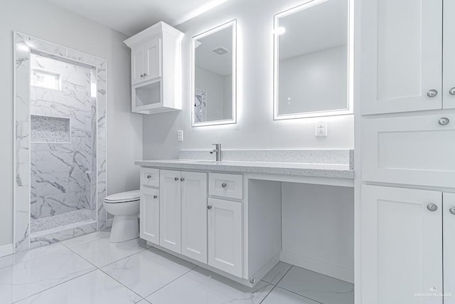 bathroom featuring tiled shower, vanity, and toilet