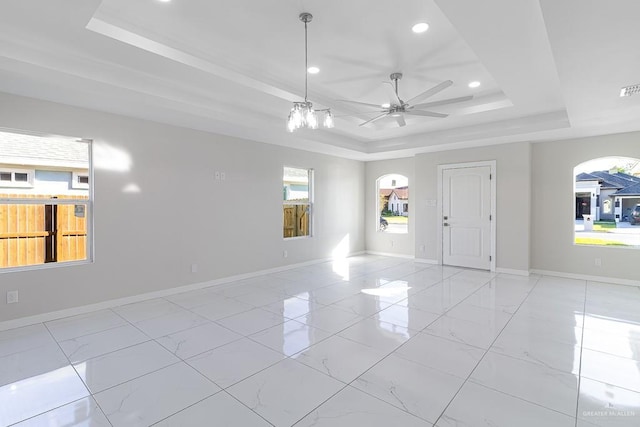 spare room with ceiling fan and a tray ceiling