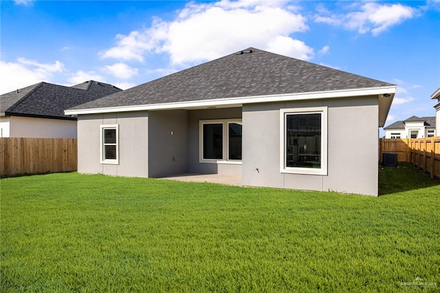 rear view of house featuring central AC unit and a yard