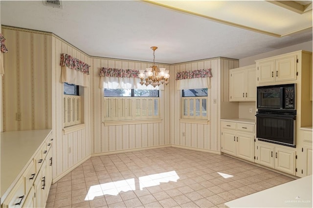 kitchen with a chandelier, light tile patterned floors, black appliances, and decorative light fixtures