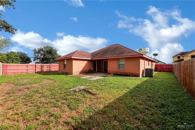 rear view of house with a yard and central air condition unit