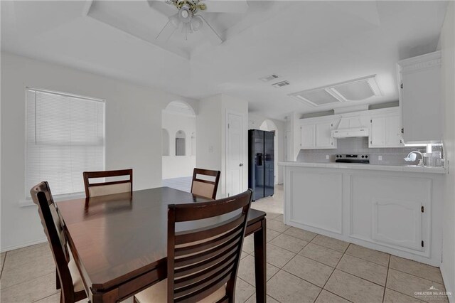 tiled dining area featuring ceiling fan and sink