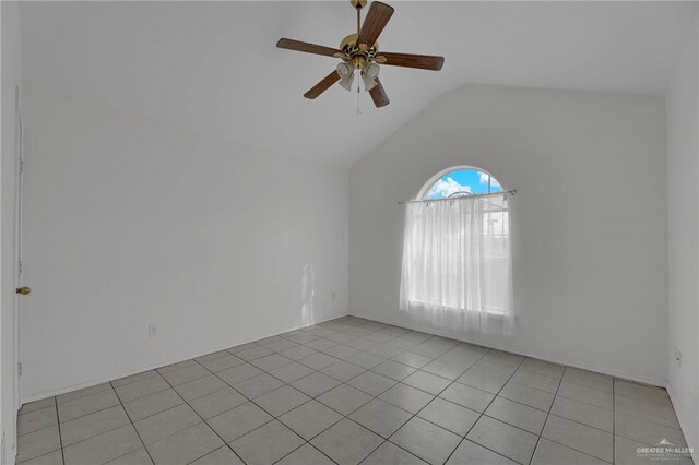 tiled empty room featuring vaulted ceiling and ceiling fan