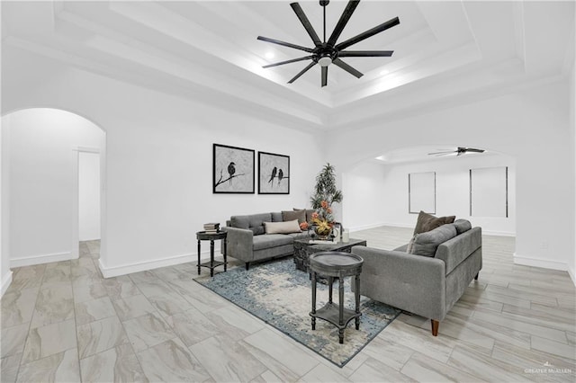 living room featuring a tray ceiling, ceiling fan, and crown molding