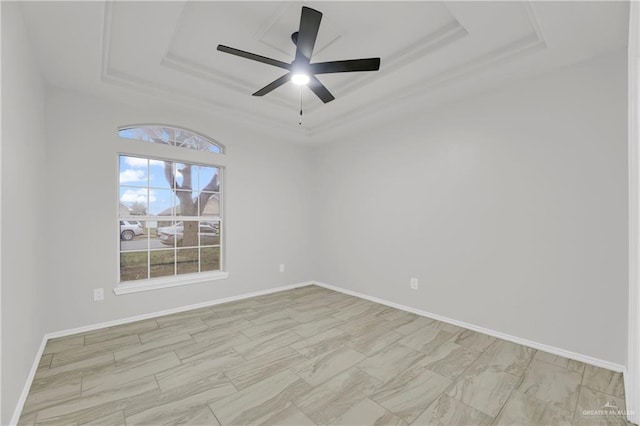 spare room with a raised ceiling and ceiling fan