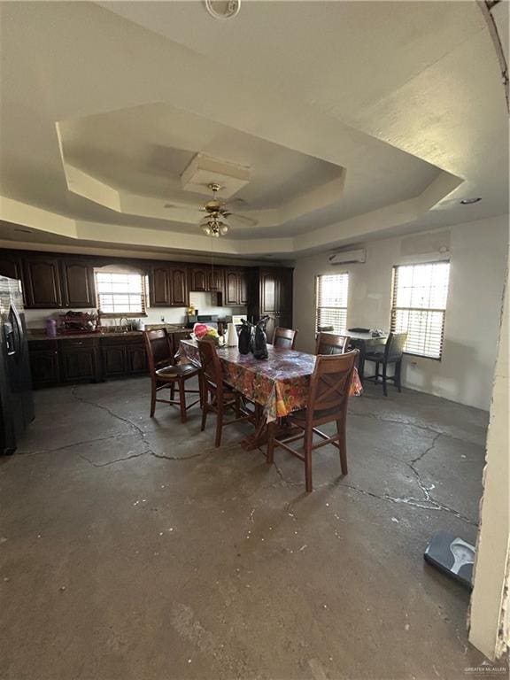 dining space featuring a tray ceiling and ceiling fan